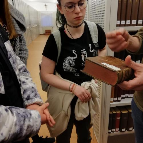Schülerin betrachtet ein Buch des Kapuzinerklosters