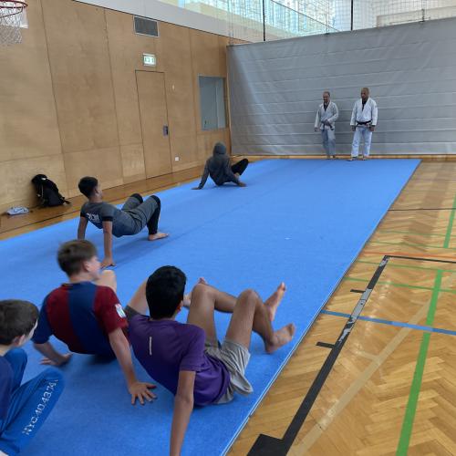 Schüler und Trainer beim Trainieren am Boden