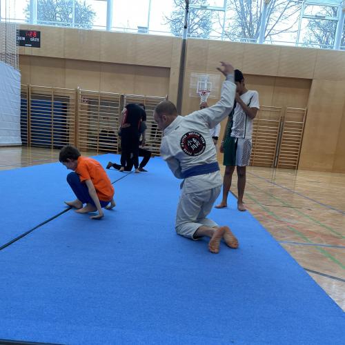 Schüler und Trainer beim Trainieren am Boden
