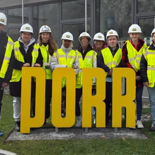 Schülergruppe vor dem Logo der Firma Porr
