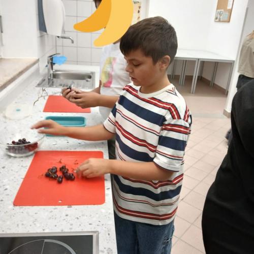 Schüler in der Küche arbeitet mit Weintrauben