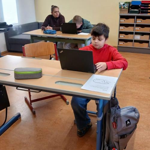 Schüler arbeiten mit Assistentin im Unterricht