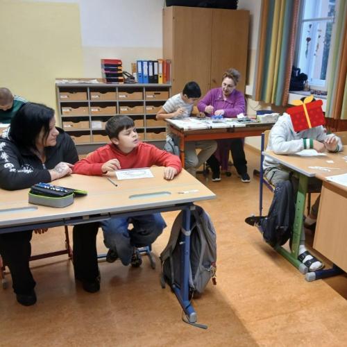 Schüler arbeiten mit Assistentin im Unterricht