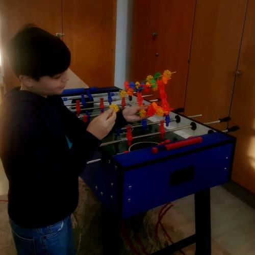 Schüler spielt am Tischfußball mit einem Knobelspiel