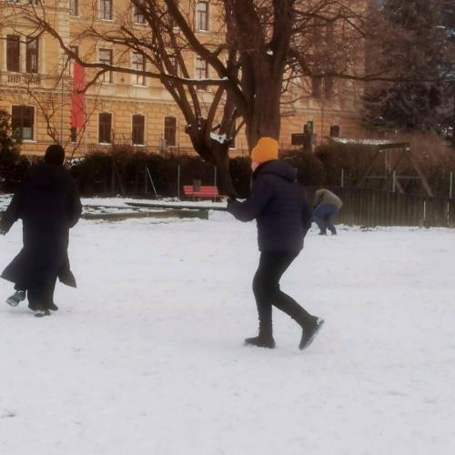 SchülerInnen aus dem Tagesheim spielen im schneebedeckten Garten 