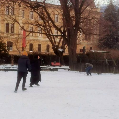 SchülerInnen aus dem Tagesheim spielen im schneebedeckten Garten