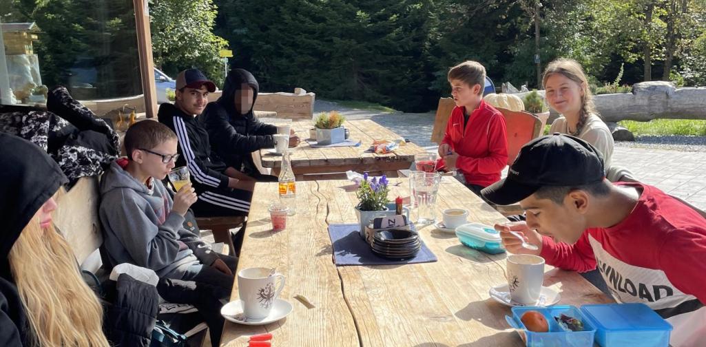 CB Schüler*innen und Lehrerin beim Jausnen auf der Enzianhütte.