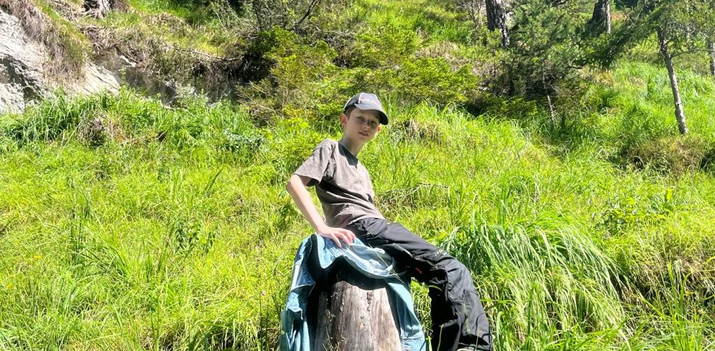 Schüler beim Chillen auf einem Baumstumpf